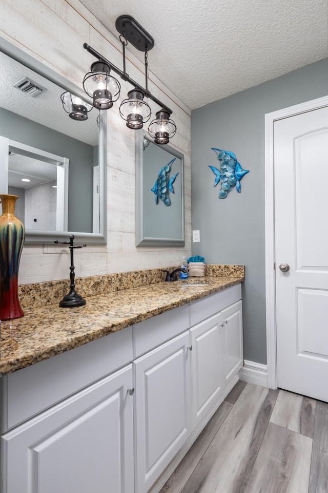 8520 Gulf Blvd Unit 29, Navarre, FL 32566 - bathroom featuring a textured ceiling, vanity, and wood finished floors