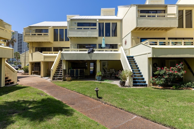 8520 Gulf Blvd Unit 29, Navarre, FL 32566 - rear view of property featuring stairway, a lawn, and a metal roof