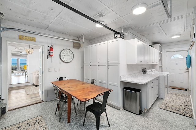 58 Montgomery St, Santa Rosa Beach, FL 32459 - kitchen featuring white cabinetry, healthy amount of natural light, light stone countertops, and dark aggregate flooring