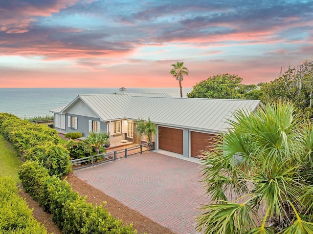 58 Montgomery St, Santa Rosa Beach, FL 32459 - view of front of home with a garage, a metal roof, decorative driveway, a standing seam roof, and stucco siding