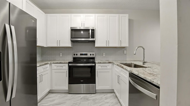 34 Herons Watch Way Unit 1202, Santa Rosa Beach, FL 32459 - kitchen with appliances with stainless steel finishes, light marble finish flooring, tasteful backsplash, and white cabinets