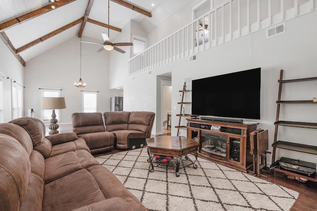 6539 Robar Tesora St, Navarre, FL 32566 - living area with high vaulted ceiling, wood finished floors, a ceiling fan, a chandelier, and beam ceiling