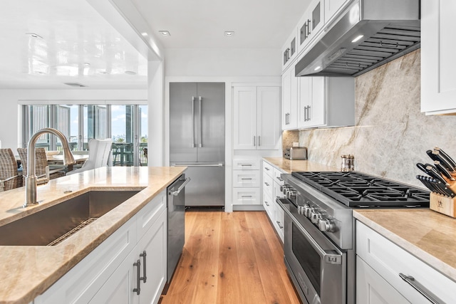 20 Mark Twain Ln Unit 402, Inlet Beach, FL 32461 - kitchen with extractor fan, high end appliances, white cabinets, light stone countertops, and backsplash