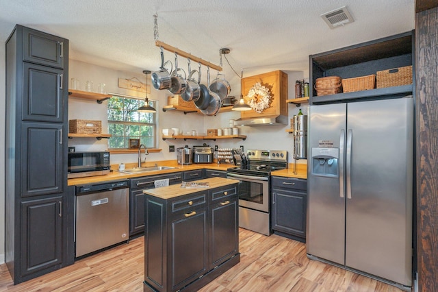 313 Lakeview Dr, Crestview, FL 32536 - kitchen featuring appliances with stainless steel finishes, open shelves, butcher block counters, range hood, and a textured ceiling