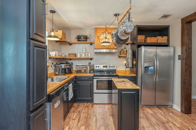 313 Lakeview Dr, Crestview, FL 32536 - kitchen with appliances with stainless steel finishes, butcher block counters, open shelves, light wood-style flooring, and a textured ceiling