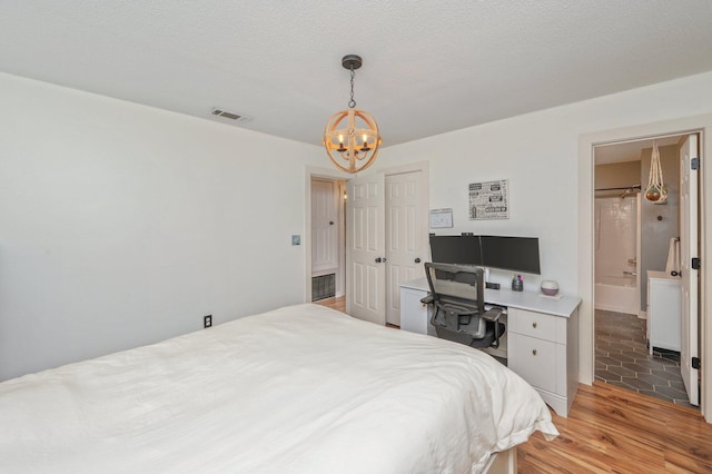 313 Lakeview Dr, Crestview, FL 32536 - bedroom featuring a chandelier, light wood finished floors, an office area, and connected bathroom