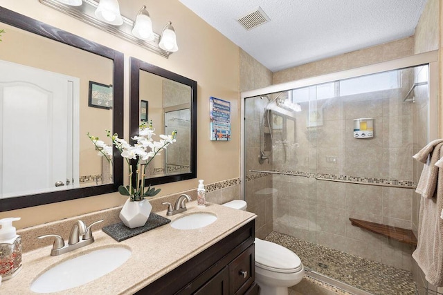 131 Wedgewood Ln, Crestview, FL 32536 - bathroom featuring a stall shower, double vanity, and a textured ceiling