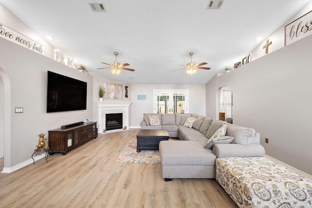 131 Wedgewood Ln, Crestview, FL 32536 - living room featuring arched walkways, ceiling fan, light wood-style flooring, a fireplace, and recessed lighting