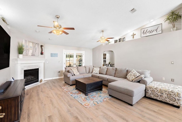 131 Wedgewood Ln, Crestview, FL 32536 - living room with ceiling fan, light wood-type flooring, a high end fireplace, arched walkways, and vaulted ceiling