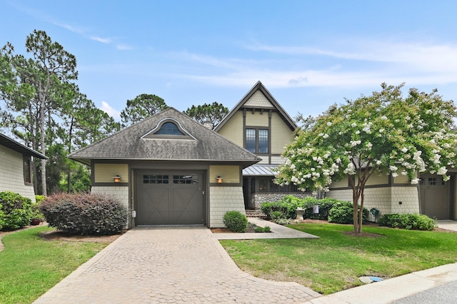 1510 Match Point Ln Unit 303, Panama City Beach, FL 32413 - view of front of house featuring a garage, a front yard, decorative driveway, and a shingled roof