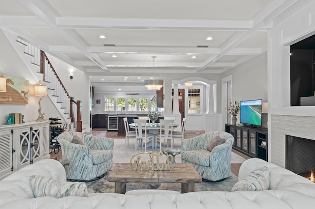 1510 Match Point Ln Unit 303, Panama City Beach, FL 32413 - living room with coffered ceiling, wine cooler, beamed ceiling, stairway, and a brick fireplace