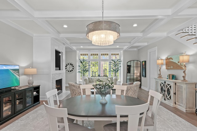 1510 Match Point Ln Unit 303, Panama City Beach, FL 32413 - dining room featuring coffered ceiling, wood finished floors, a warm lit fireplace, a chandelier, and beam ceiling