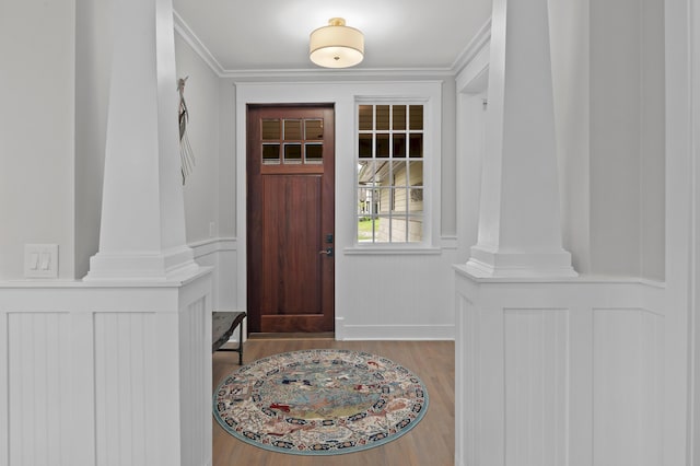 1510 Match Point Ln Unit 303, Panama City Beach, FL 32413 - foyer entrance featuring ornate columns, wood finished floors, a decorative wall, and ornamental molding
