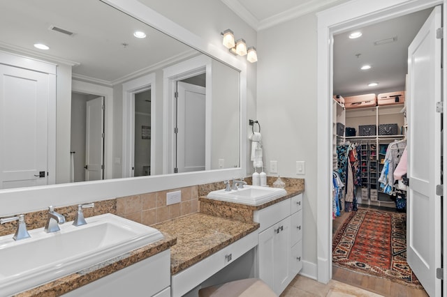 1510 Match Point Ln Unit 303, Panama City Beach, FL 32413 - bathroom with double vanity, a walk in closet, recessed lighting, crown molding, and backsplash