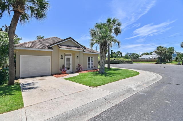 113 Mantero Way, Destin, FL 32541 - view of front facade featuring a tiled roof, stucco siding, a garage, driveway, and a front lawn