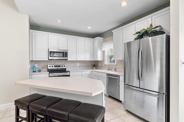 113 Mantero Way, Destin, FL 32541 - kitchen with stainless steel appliances, white cabinets, light countertops, light tile patterned floors, and recessed lighting