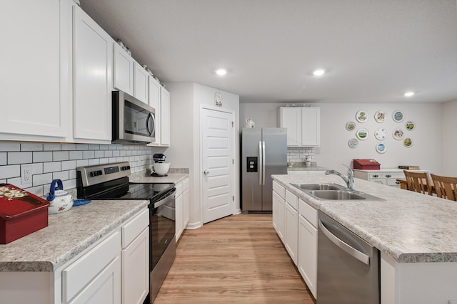 6721 Sarah Ann Way, Laurel Hill, FL 32567 - kitchen with appliances with stainless steel finishes, light wood finished floors, tasteful backsplash, white cabinetry, and recessed lighting