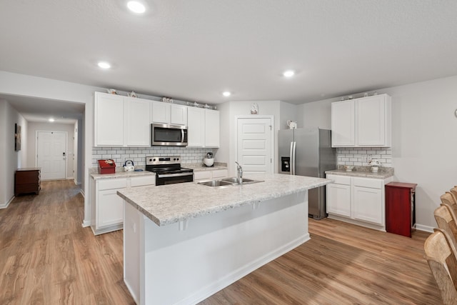 6721 Sarah Ann Way, Laurel Hill, FL 32567 - kitchen featuring appliances with stainless steel finishes, light wood finished floors, light countertops, decorative backsplash, and white cabinetry