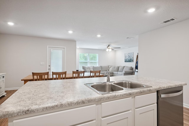 6721 Sarah Ann Way, Laurel Hill, FL 32567 - kitchen featuring stainless steel dishwasher, wood finished floors, white cabinets, open floor plan, and light countertops