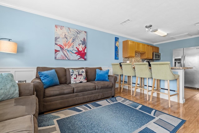 445 Gulf Shore Dr Unit 206, Destin, FL 32541 - living room featuring crown molding, light wood finished floors, wainscoting, and a decorative wall