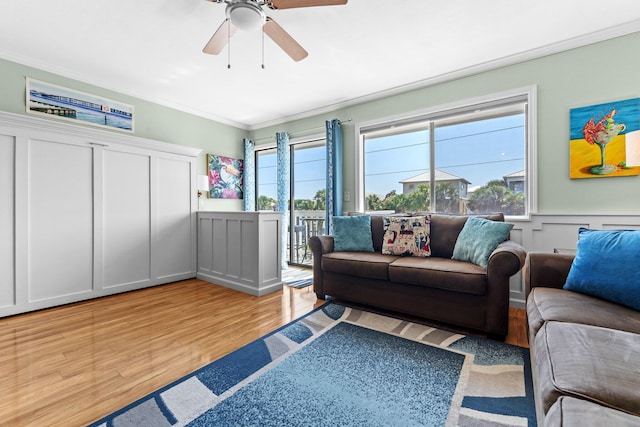 445 Gulf Shore Dr Unit 206, Destin, FL 32541 - living room featuring crown molding, light wood-style floors, ceiling fan, a wainscoted wall, and a decorative wall