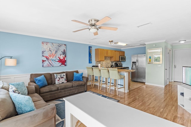 445 Gulf Shore Dr Unit 206, Destin, FL 32541 - living room featuring crown molding, light wood finished floors, ceiling fan, and a wainscoted wall