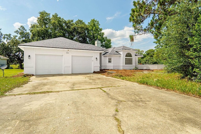 1005 Shalimar Point Dr, Shalimar, FL 32579 - view of front of property featuring concrete driveway, a chimney, stucco siding, an attached garage, and roof with shingles