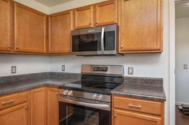 24 W Violet Ln, Defuniak Springs, FL 32433 - kitchen with stainless steel appliances, dark countertops, and brown cabinets
