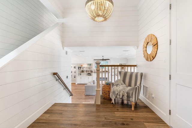 192 Lake Pointe Dr, Santa Rosa Beach, FL 32459 - living area with wooden walls, wood finished floors, a chandelier, crown molding, and an upstairs landing