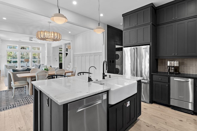 395 Tumblehome Way, Santa Rosa Beach, FL 32459 - kitchen featuring stacked washing machine and dryer, appliances with stainless steel finishes, light wood finished floors, open floor plan, and recessed lighting
