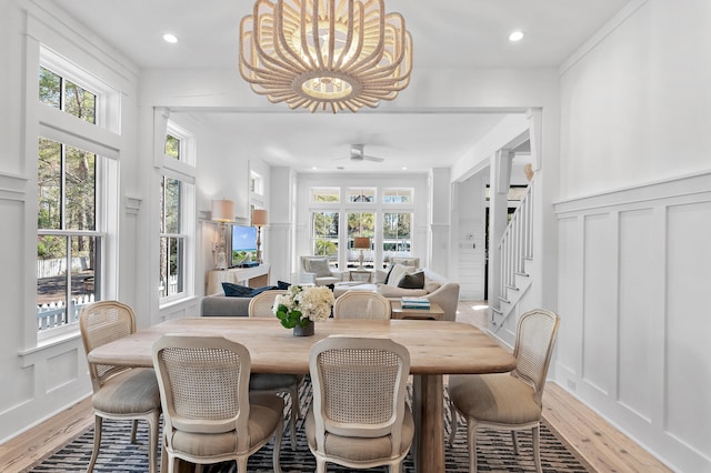 395 Tumblehome Way, Santa Rosa Beach, FL 32459 - dining area featuring a decorative wall, light wood-style floors, healthy amount of natural light, a chandelier, and stairs