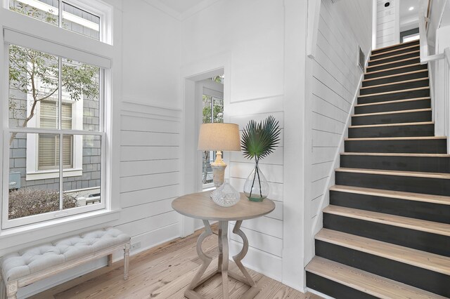 395 Tumblehome Way, Santa Rosa Beach, FL 32459 - stairway with wood finished floors, a towering ceiling, radiator heating unit, and crown molding