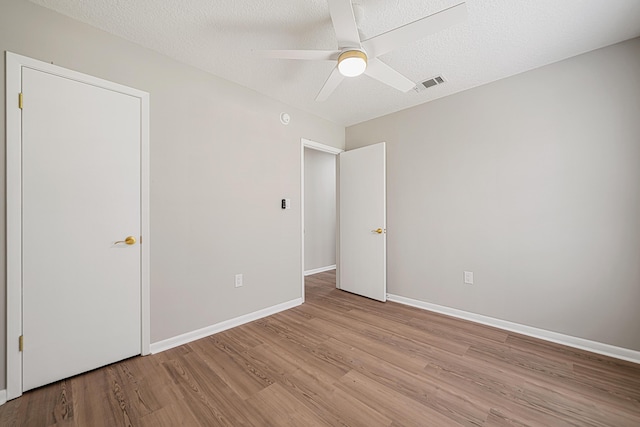 2899 Wisteria Ave, Crestview, FL 32539 - unfurnished bedroom featuring light wood-style flooring, ceiling fan, and a textured ceiling