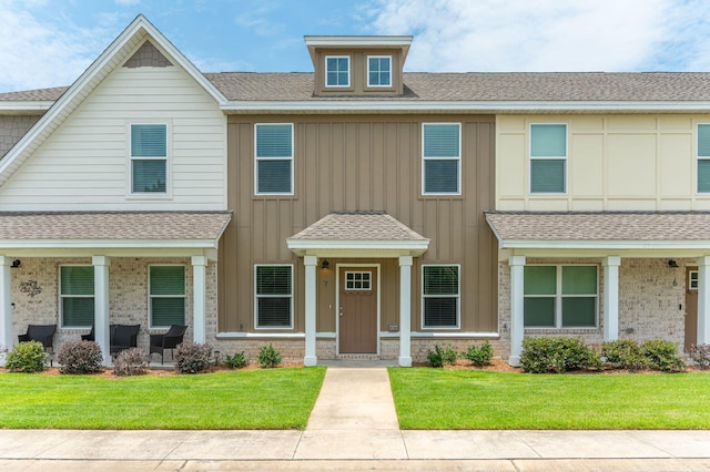 400 Mattie M Kelly Blvd Unit 7, Destin, FL 32541 - view of property with a front lawn, a shingled roof, board and batten siding, and brick siding