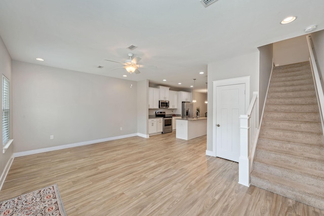 400 Mattie M Kelly Blvd Unit 7, Destin, FL 32541 - unfurnished living room with stairway, a ceiling fan, light wood-style flooring, and recessed lighting
