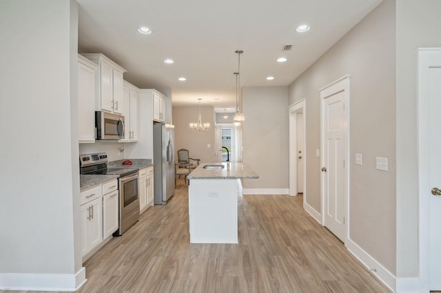 400 Mattie M Kelly Blvd Unit 7, Destin, FL 32541 - kitchen featuring stainless steel appliances, white cabinets, a kitchen island with sink, light wood-style floors, and recessed lighting
