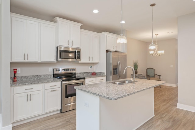 400 Mattie M Kelly Blvd Unit 7, Destin, FL 32541 - kitchen featuring stainless steel appliances, an island with sink, white cabinets, light wood finished floors, and recessed lighting