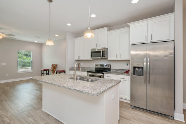 400 Mattie M Kelly Blvd Unit 7, Destin, FL 32541 - kitchen with stainless steel appliances, a center island with sink, light wood-type flooring, white cabinetry, and recessed lighting