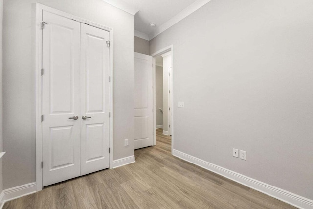 54 Kara Lake Dr, Santa Rosa Beach, FL 32459 - unfurnished bedroom featuring light wood-style flooring, a closet, and crown molding