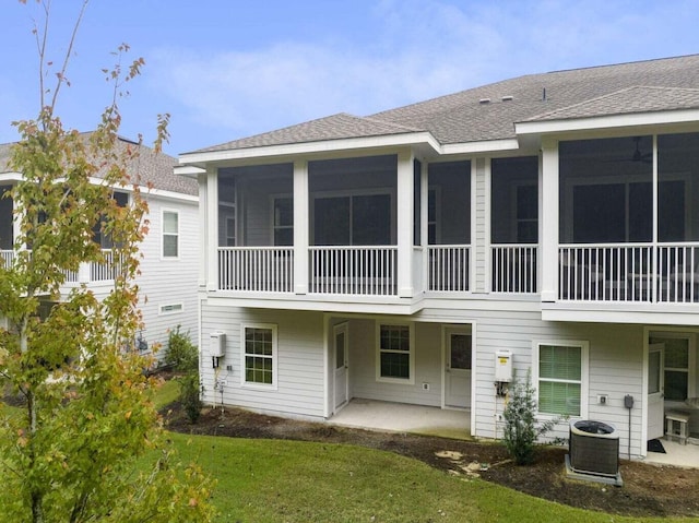 54 Kara Lake Dr, Santa Rosa Beach, FL 32459 - back of house featuring a shingled roof, a lawn, a sunroom, and a patio area