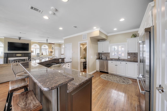 2905 Scenic Gulf Dr, Miramar Beach, FL 32550 - kitchen with appliances with stainless steel finishes, open floor plan, light wood-style floors, healthy amount of natural light, and crown molding