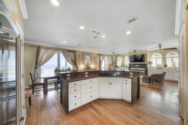 2905 Scenic Gulf Dr, Miramar Beach, FL 32550 - kitchen with crown molding, light wood-type flooring, white cabinetry, recessed lighting, and open floor plan