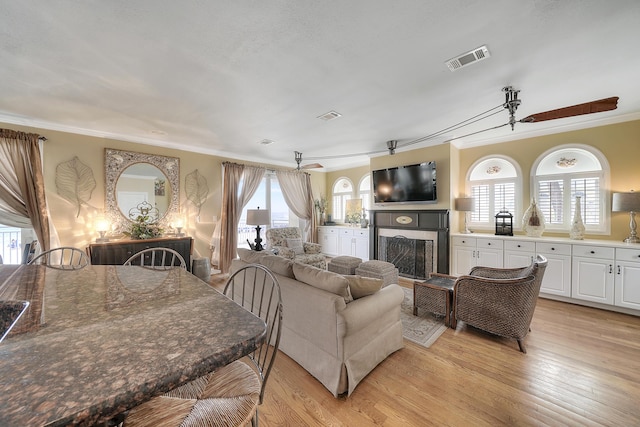 2905 Scenic Gulf Dr, Miramar Beach, FL 32550 - living area featuring crown molding, a fireplace, light wood-style flooring, and plenty of natural light