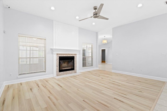 2050 Biscayne Blvd, Navarre, FL 32566 - unfurnished living room with a ceiling fan, a tiled fireplace, light wood-style floors, and recessed lighting