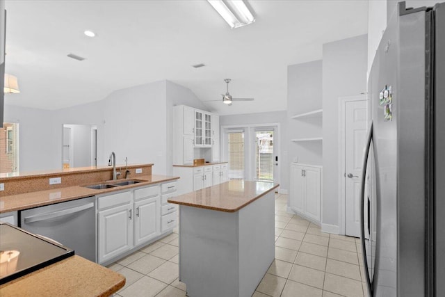2050 Biscayne Blvd, Navarre, FL 32566 - kitchen with appliances with stainless steel finishes, vaulted ceiling, white cabinets, a kitchen island, and light tile patterned flooring