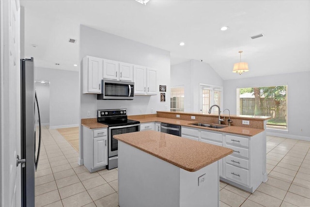 2050 Biscayne Blvd, Navarre, FL 32566 - kitchen with appliances with stainless steel finishes, light tile patterned floors, a peninsula, a center island, and vaulted ceiling