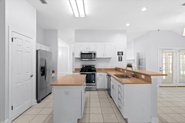 2050 Biscayne Blvd, Navarre, FL 32566 - kitchen featuring stainless steel appliances, a peninsula, light tile patterned flooring, white cabinetry, and a kitchen island