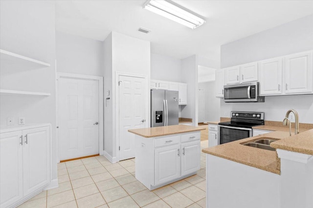 2050 Biscayne Blvd, Navarre, FL 32566 - kitchen featuring appliances with stainless steel finishes, white cabinets, a center island, light tile patterned floors, and light stone counters
