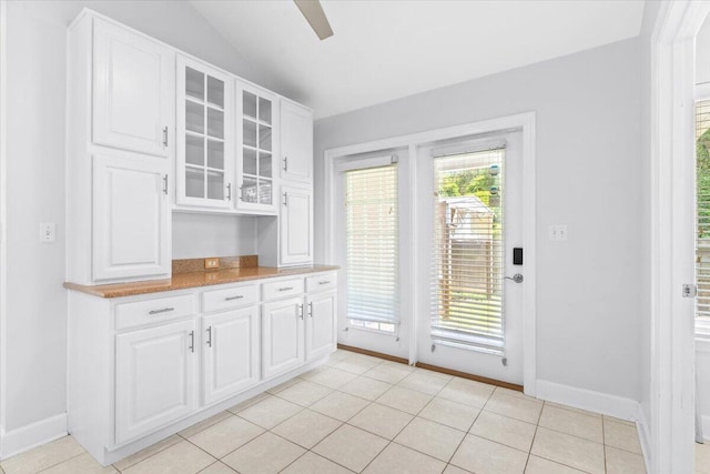 2050 Biscayne Blvd, Navarre, FL 32566 - kitchen featuring glass insert cabinets, vaulted ceiling, white cabinetry, and light tile patterned floors