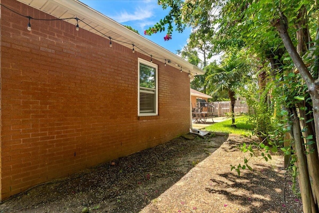 2050 Biscayne Blvd, Navarre, FL 32566 - view of side of home with brick siding and a patio area